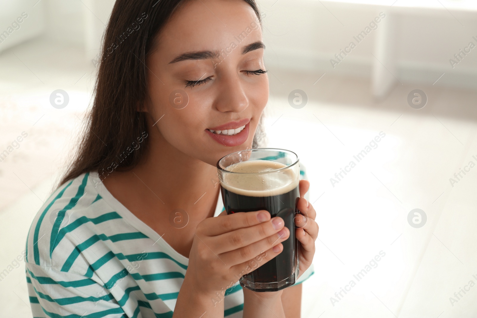 Photo of Beautiful woman with cold kvass indoors. Traditional Russian summer drink