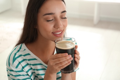 Beautiful woman with cold kvass indoors. Traditional Russian summer drink