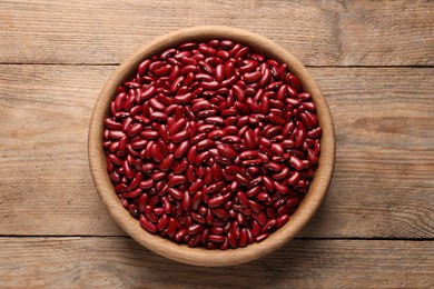 Raw red kidney beans in bowl on wooden table, top view