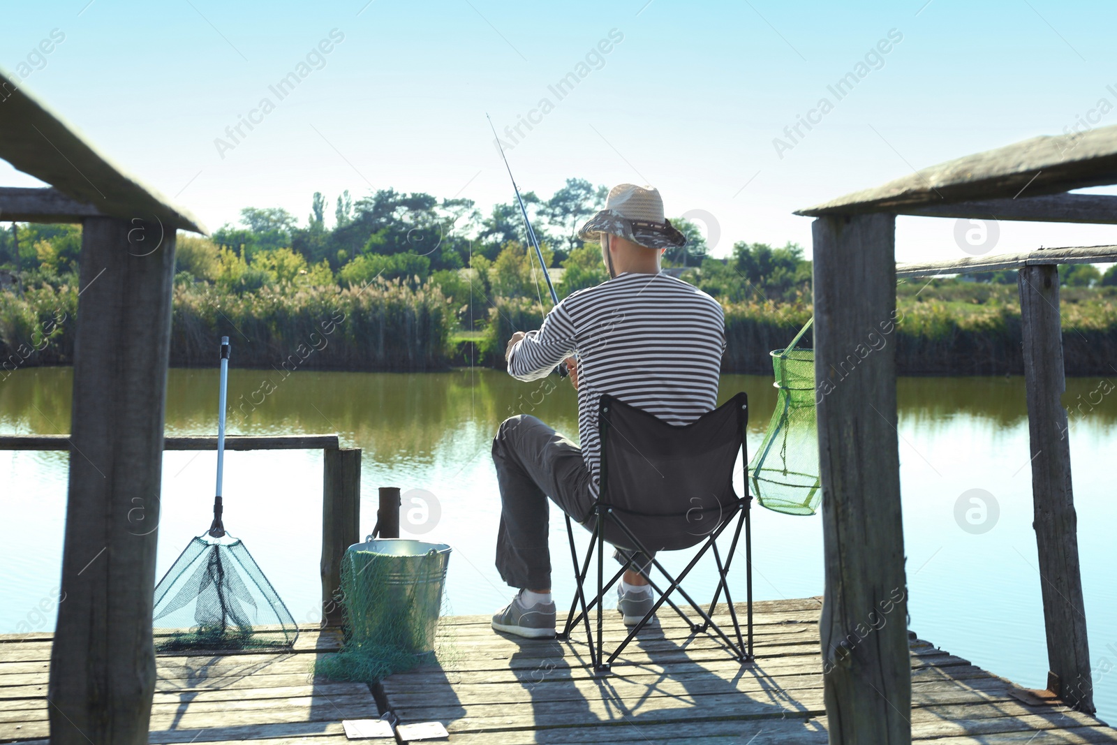 Photo of Young man fishing alone on sunny day
