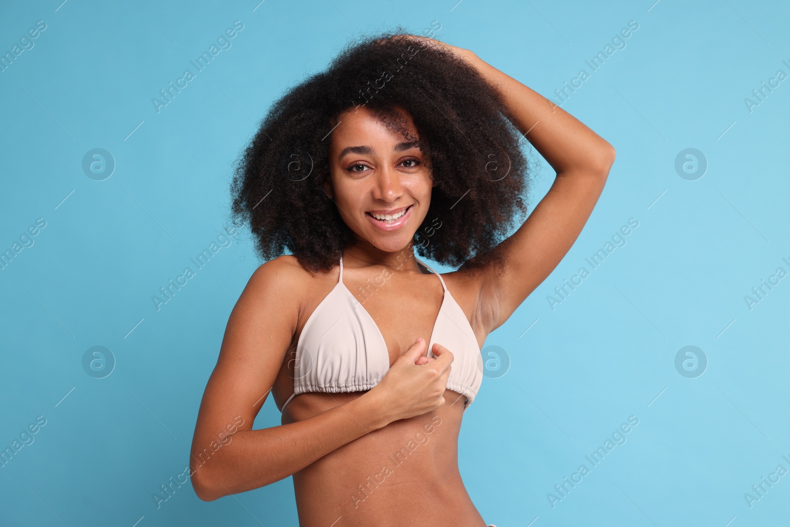 Photo of Beautiful woman in stylish bikini on light blue background