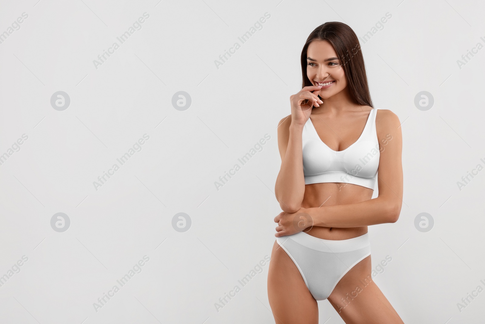 Photo of Young woman in stylish bikini on white background. Space for text