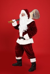 Photo of Santa Claus with electric guitar on red background. Christmas music