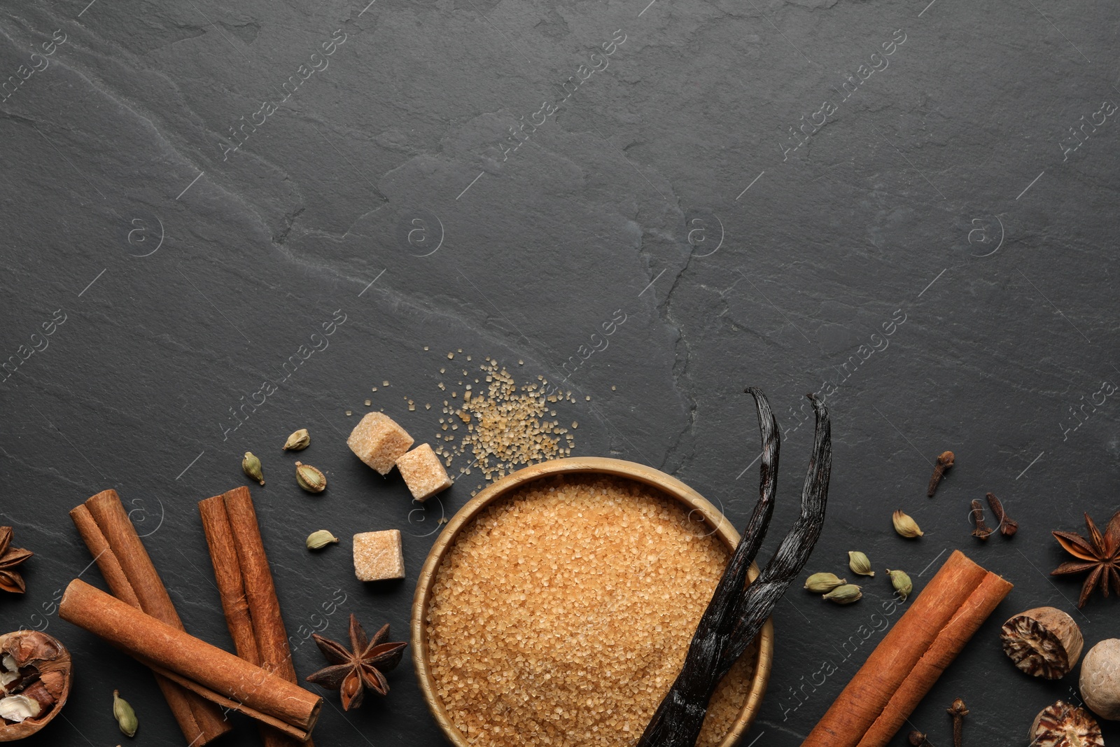 Photo of Different aromatic spices on dark textured table, flat lay. Space for text