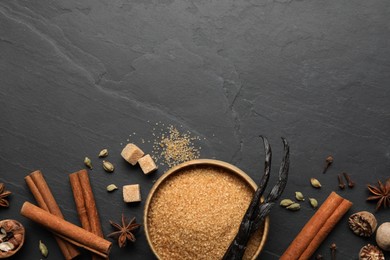 Photo of Different aromatic spices on dark textured table, flat lay. Space for text