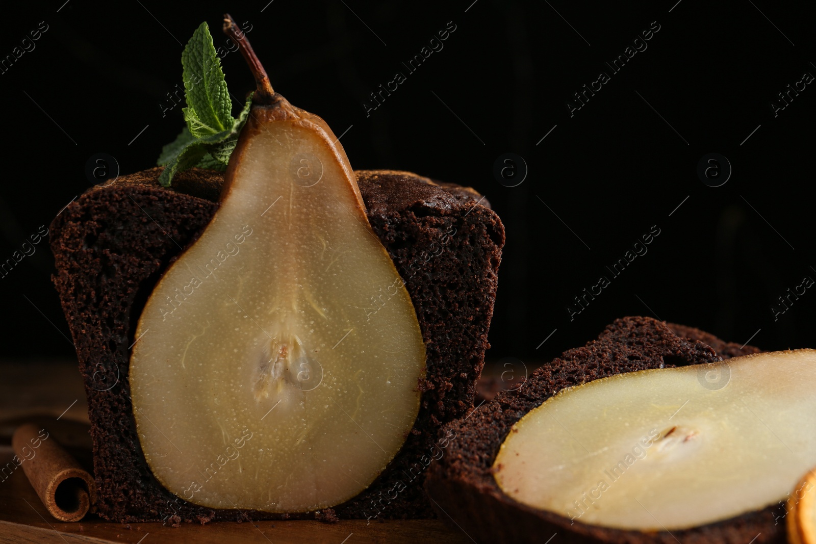 Photo of Tasty pear bread with mint and cinnamon on wooden table, closeup. Homemade cake