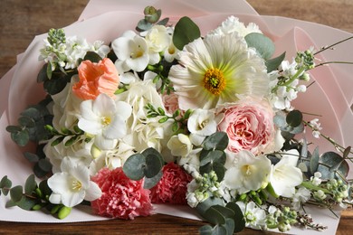 Bouquet of beautiful flowers on wooden table, closeup