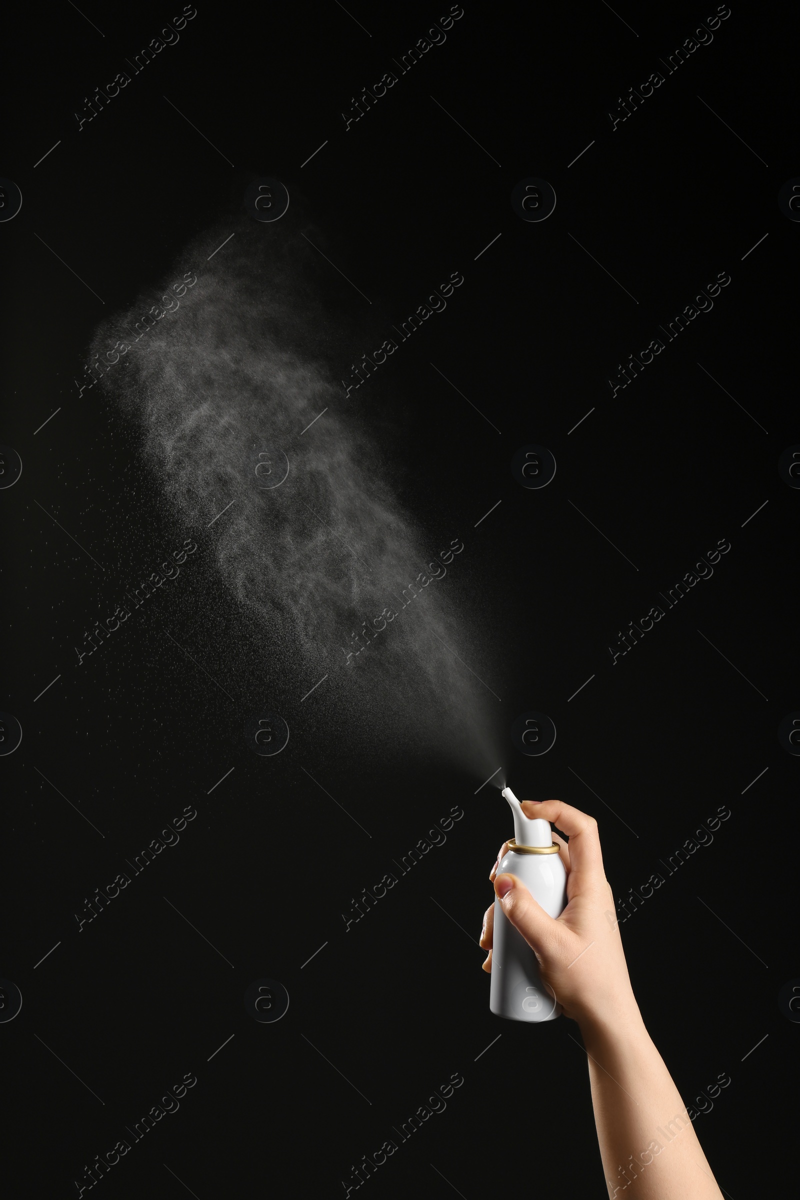 Photo of Nasal congestion. Woman spraying remedy from bottle on black background, closeup