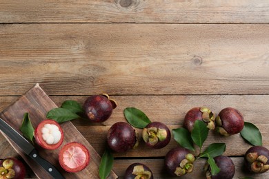 Photo of Delicious tropical mangosteens on wooden table, flat lay. Space for text