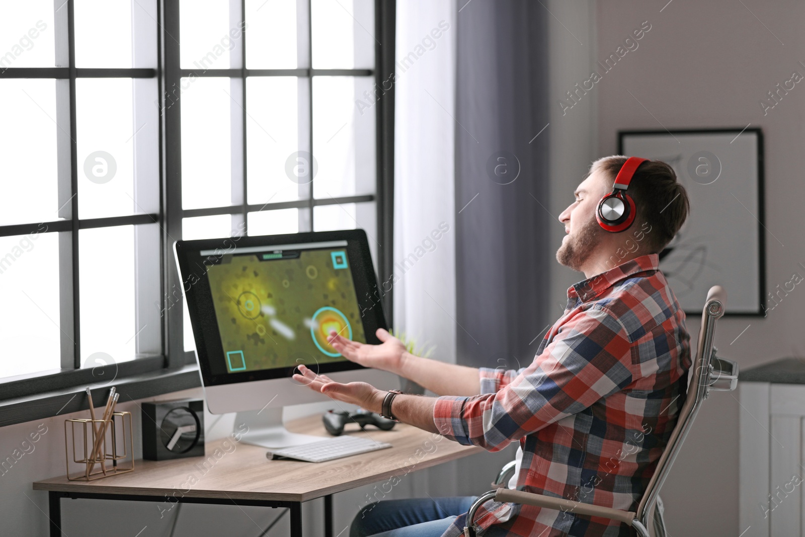 Photo of Young man playing video game at home