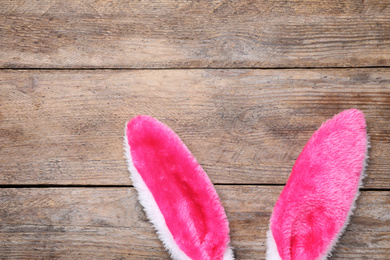 Decorative bunny ears and space for text on wooden background, flat lay. Easter holiday