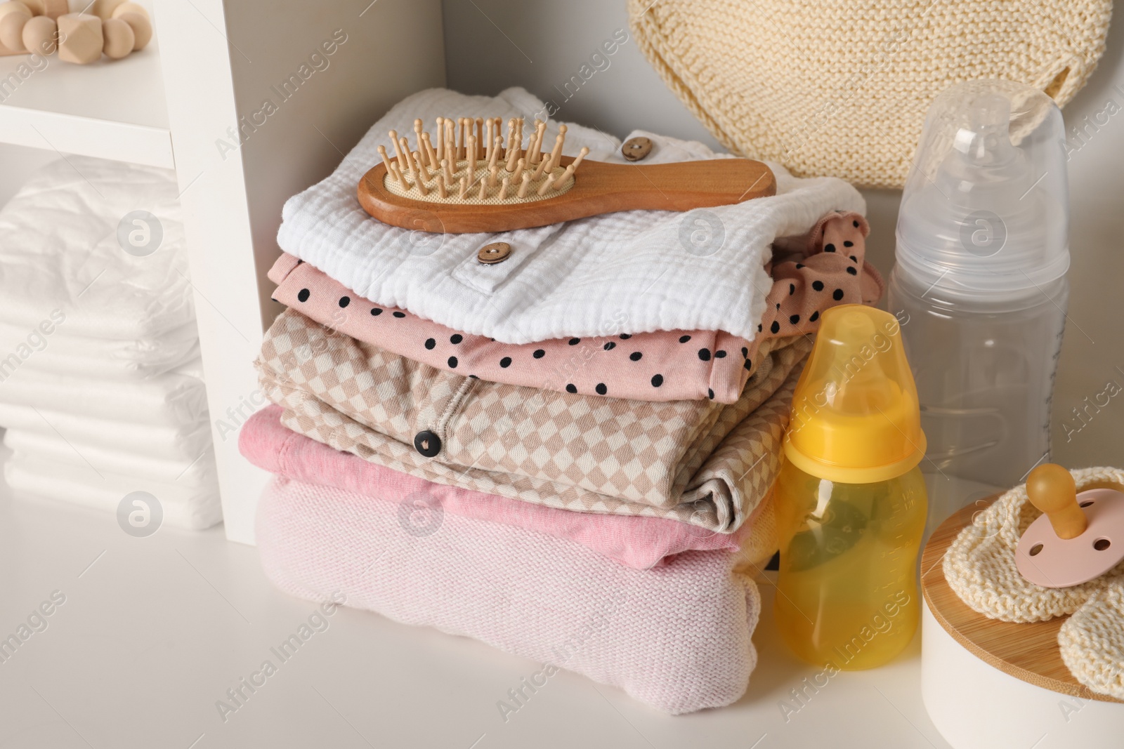 Photo of Baby clothes and accessories on white rack