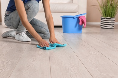 Young woman washing floor with rag, closeup with space for text. Cleaning service