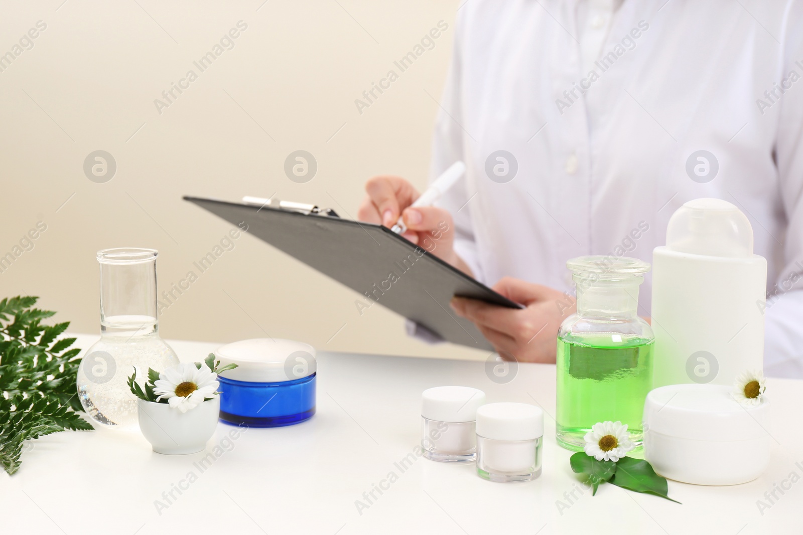 Photo of Female dermatologist doing research for new skin care product at table, closeup