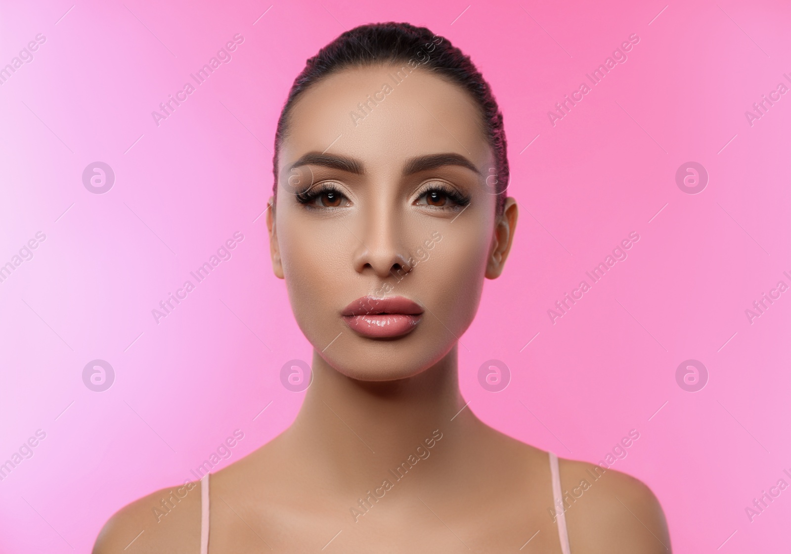 Photo of Beautiful woman with glossy lipstick on pink background