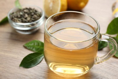 Photo of Cup of herbal diet tea on wooden table, closeup