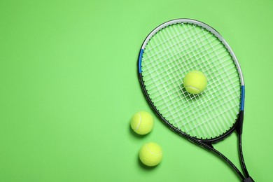 Photo of Tennis racket and balls on green background, flat lay. Space for text