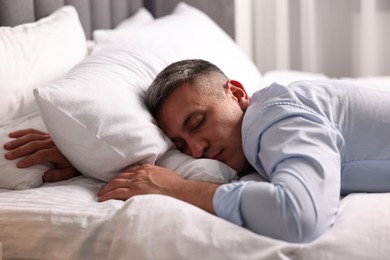 Businessman in office clothes sleeping on bed indoors