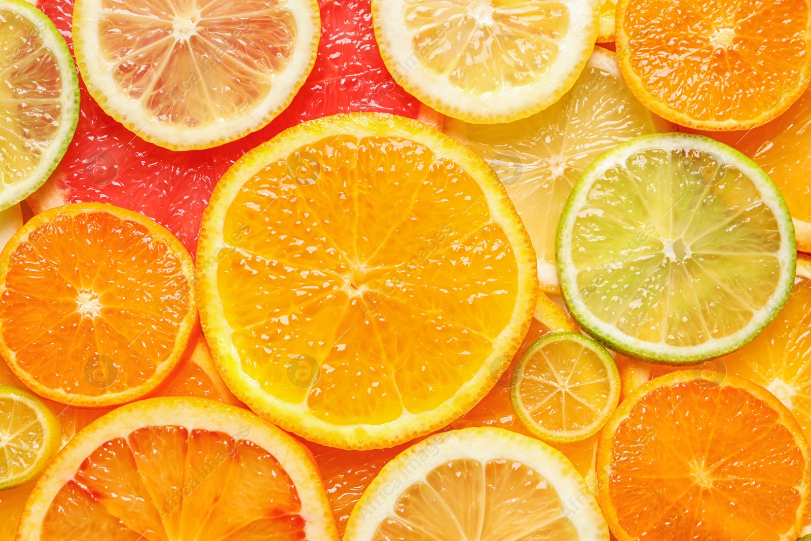 Photo of Slices of fresh citrus fruits as background, top view