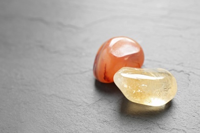 Photo of Orange gemstones on grey table, space for text