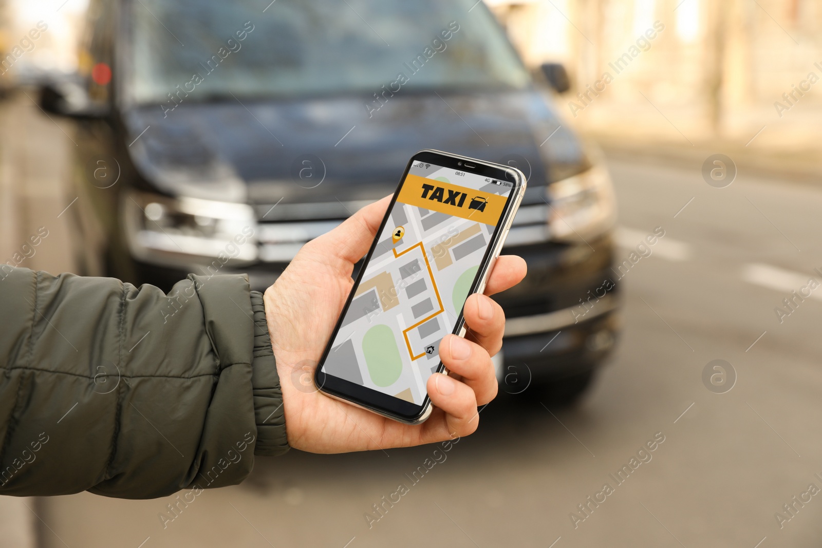 Photo of Man ordering taxi with smartphone on city street, closeup