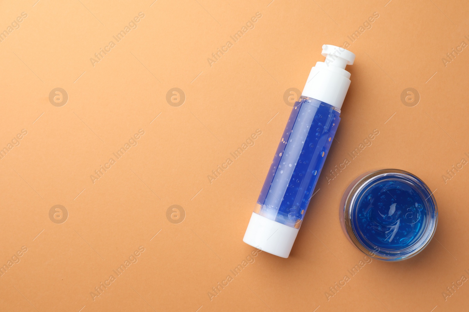 Photo of Bottle and jar of cosmetic products on orange background, flat lay. Space for text