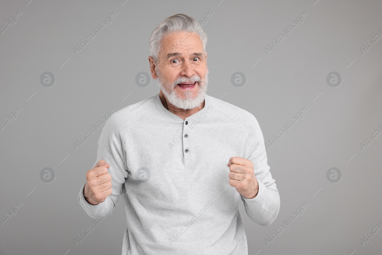 Photo of Portrait of surprised senior man on grey background