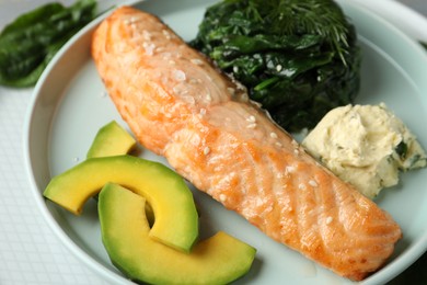 Photo of Tasty salmon with spinach and avocado on plate, closeup