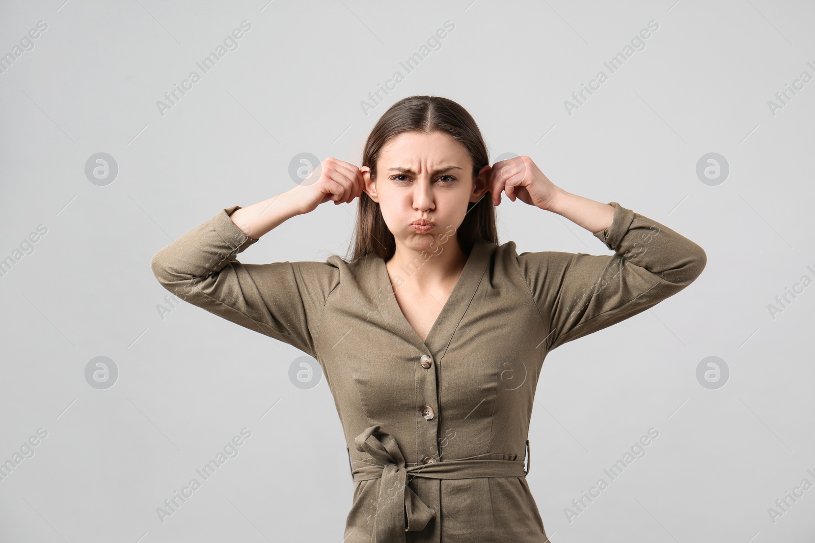 Photo of Young woman having fun on light grey background. Personality concept