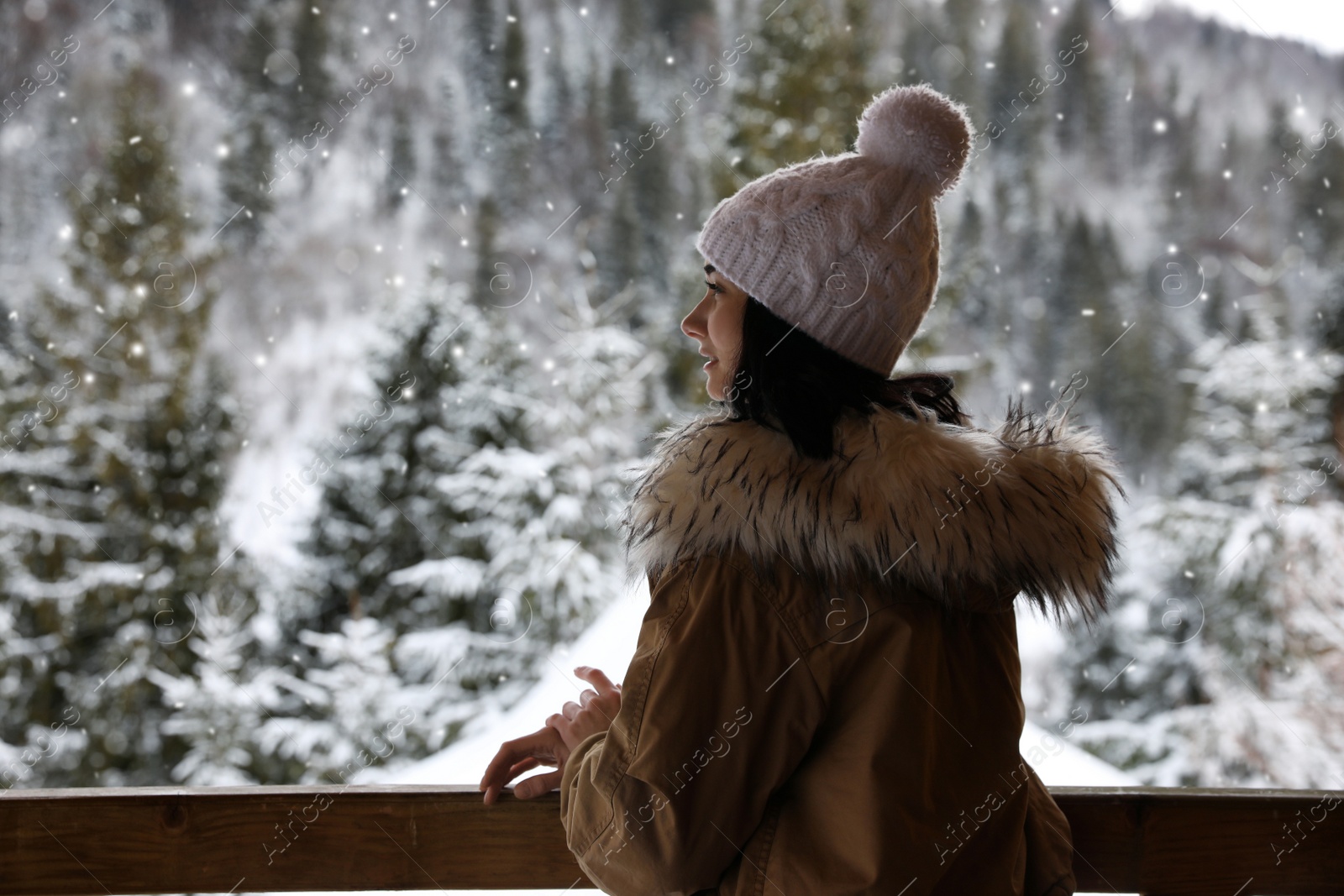 Photo of Happy woman near wooden railing. Winter vacation