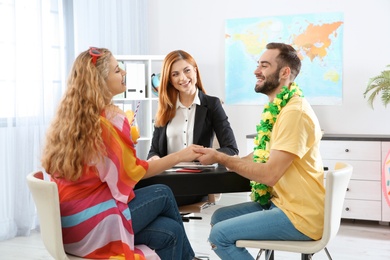 Photo of Beautiful young couple visiting travel agency office