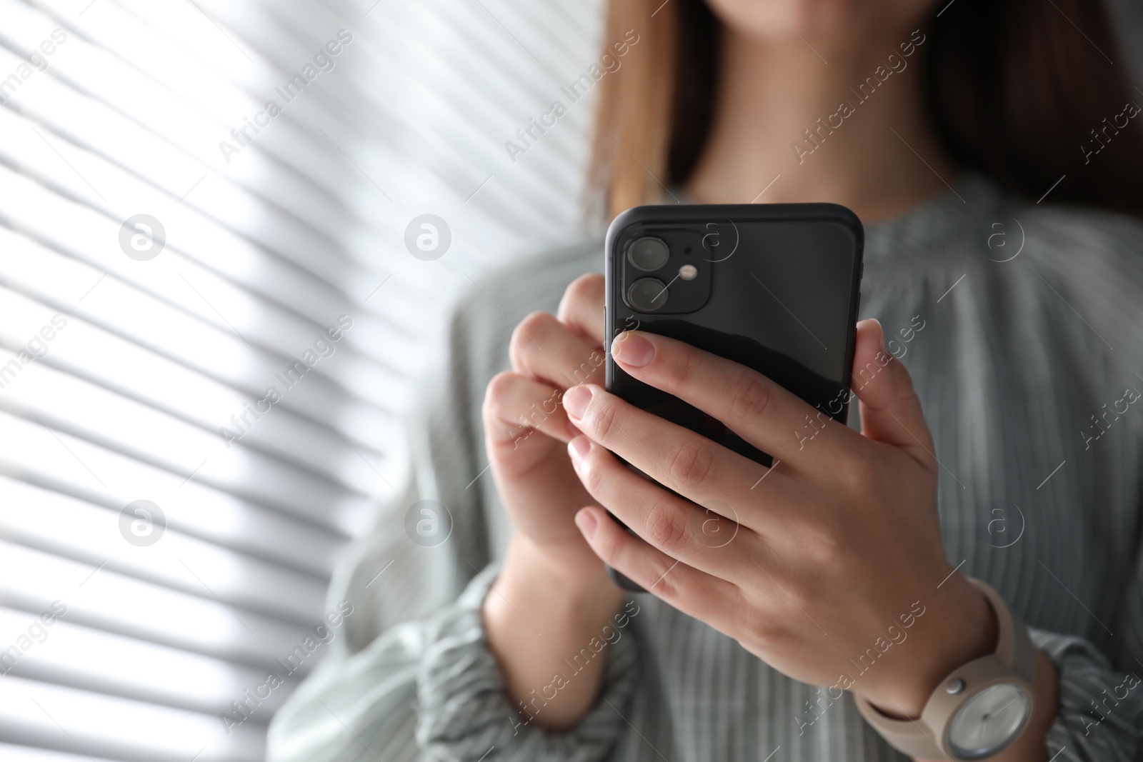 Photo of MYKOLAIV, UKRAINE - MARCH 16, 2020: Woman holding iPhone 11 Black indoors, closeup
