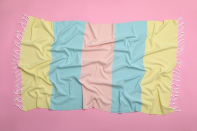 Photo of Crumpled striped beach towel on pink background, top view