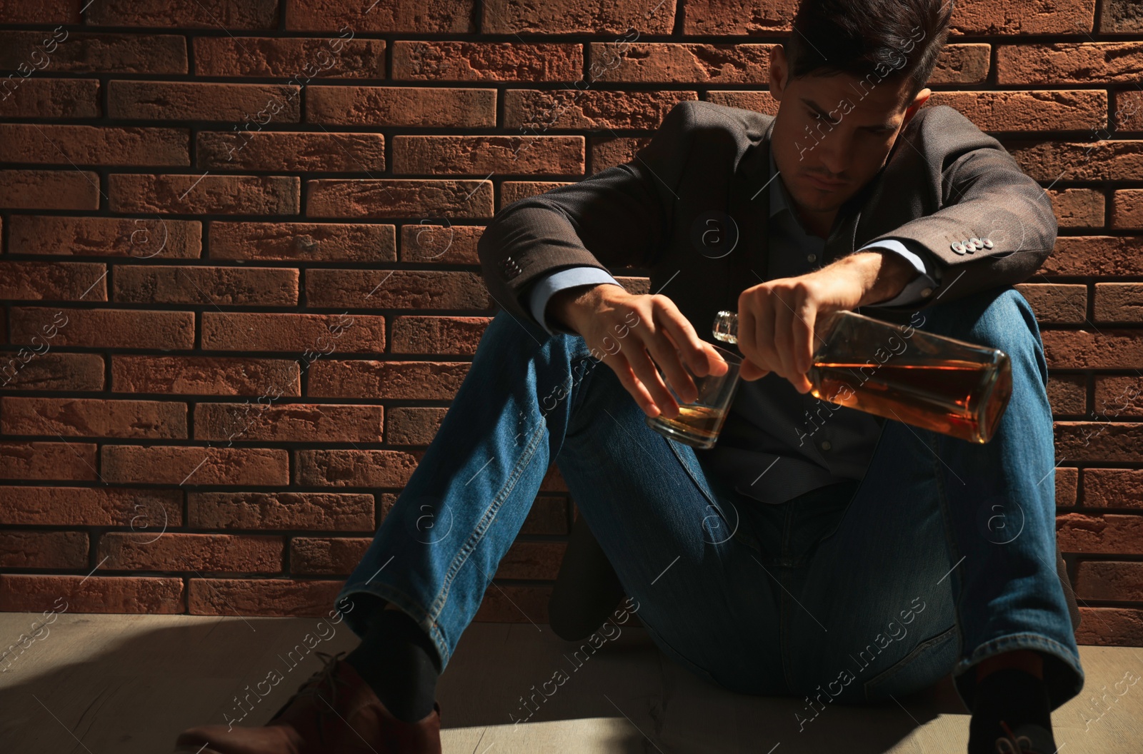 Photo of Addicted man with alcoholic drink near red brick wall. Space for text