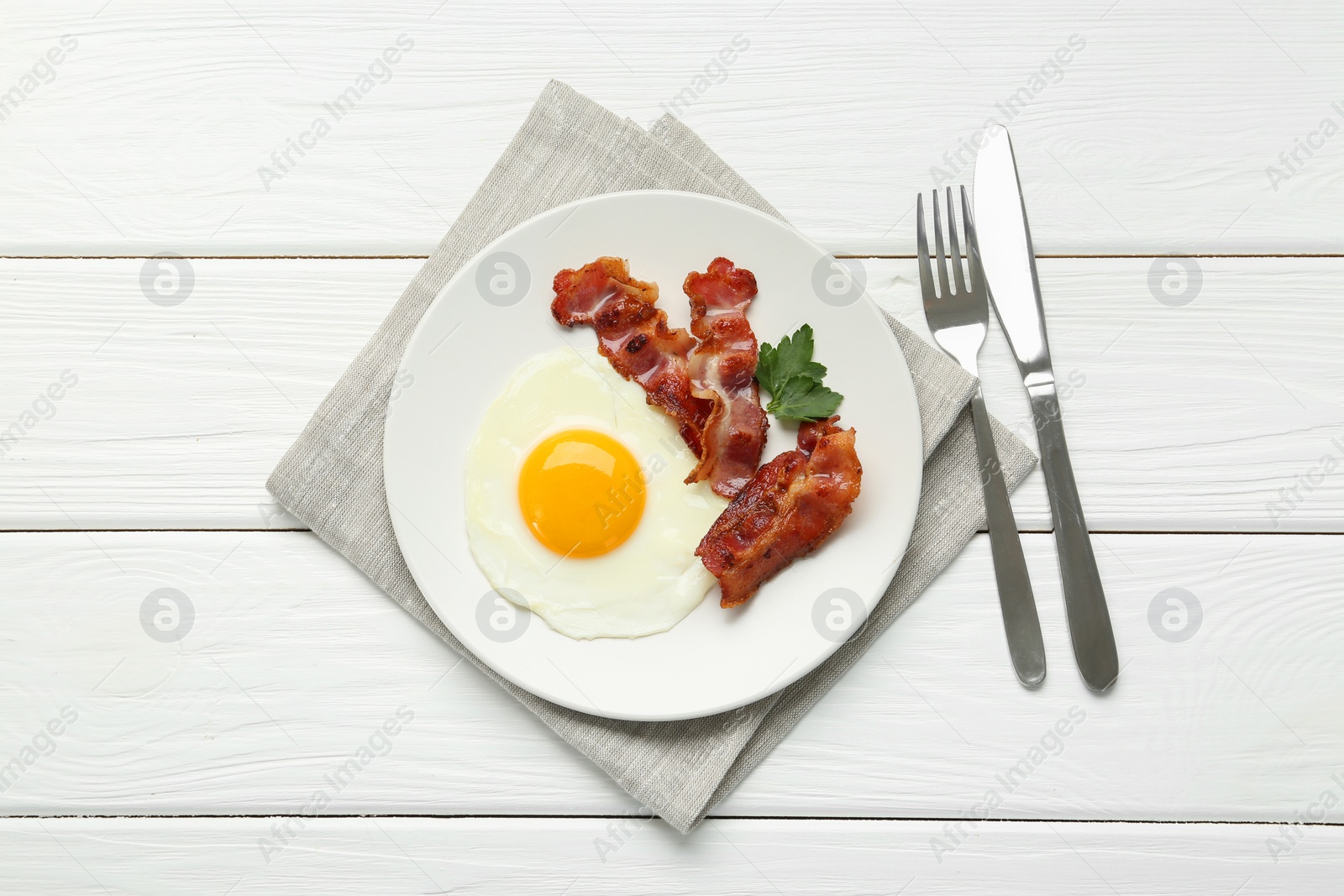 Photo of Delicious breakfast with sunny side up egg served on white wooden table, top view