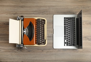 Photo of Old typewriter and laptop on wooden table, flat lay. Concept of technology progress