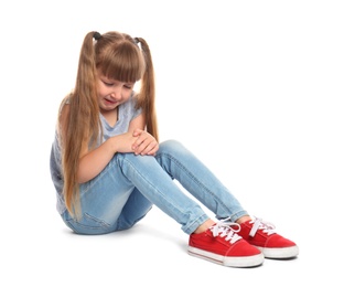 Photo of Full length portrait of little girl with knee problems sitting on white background