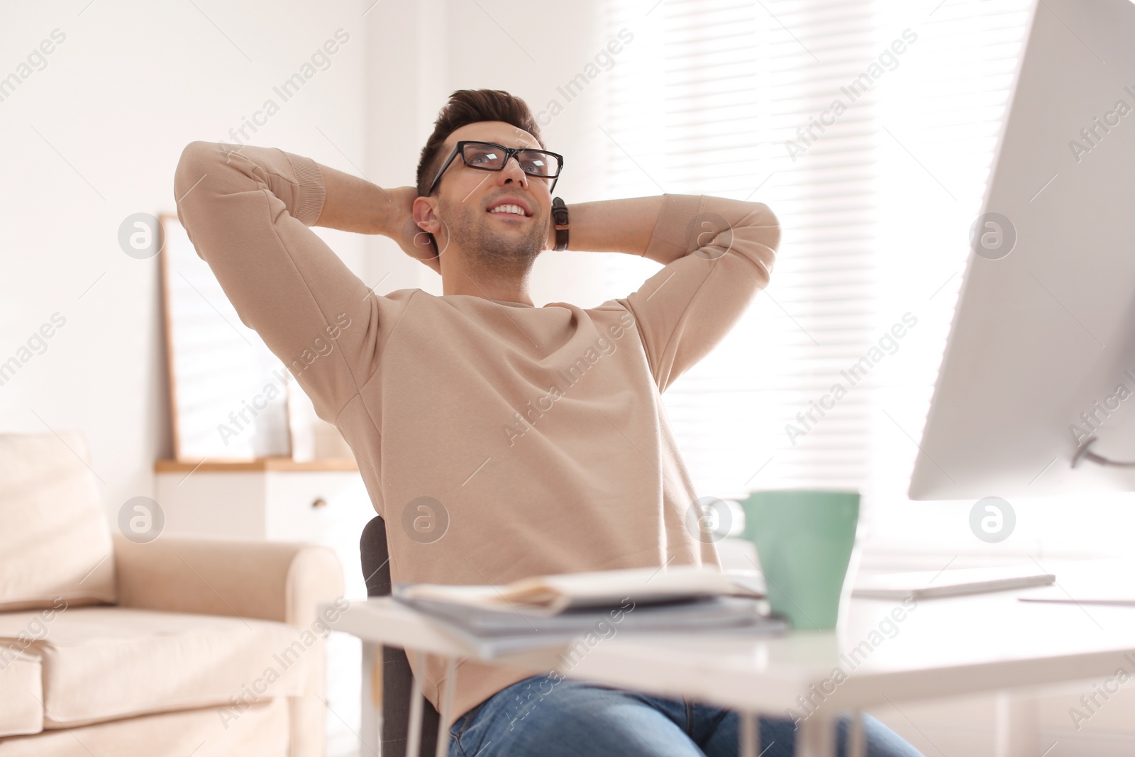 Photo of Young man relaxing at table in office during break