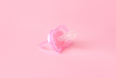 One new baby pacifier on pink background