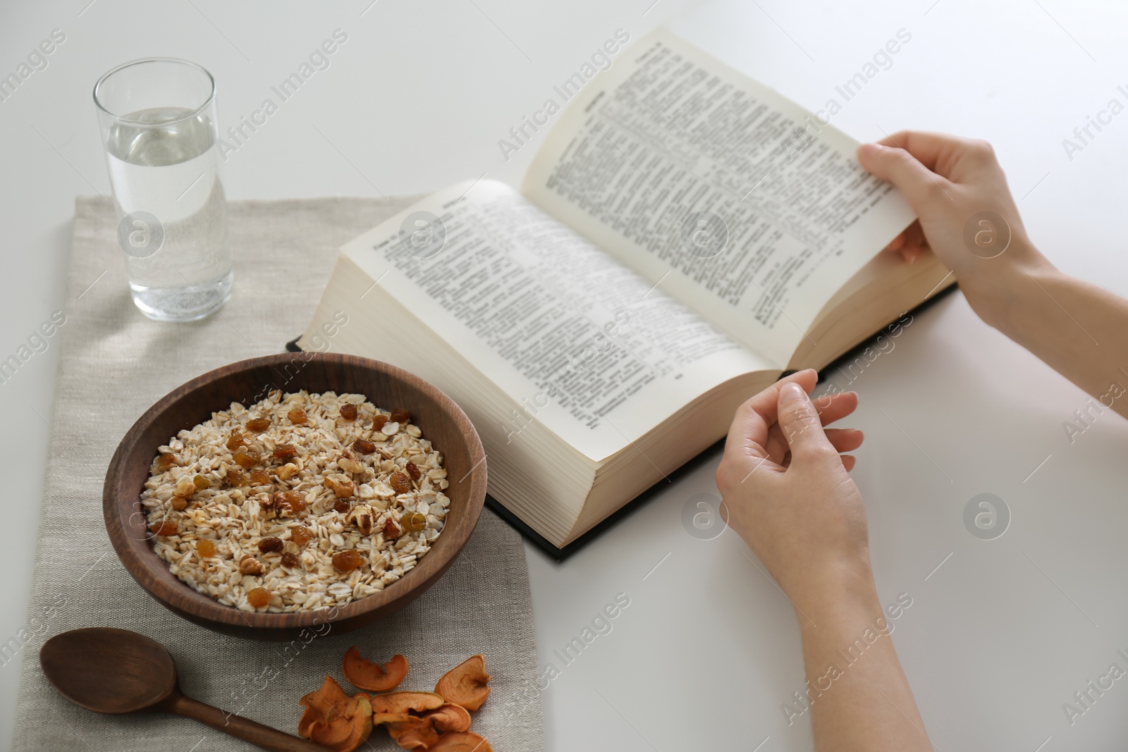 Photo of Woman with Bible having dinner at home, closeup. Great Lent season