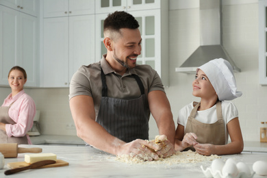 Happy family cooking together in kitchen at home