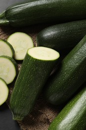 Whole and cut ripe zucchinis on table, flat lay