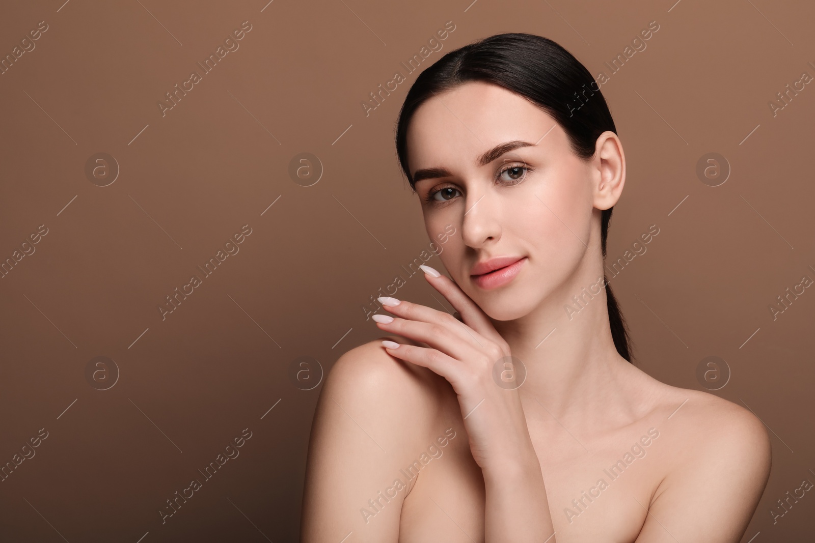 Photo of Portrait of beautiful young woman on brown background. Space for text