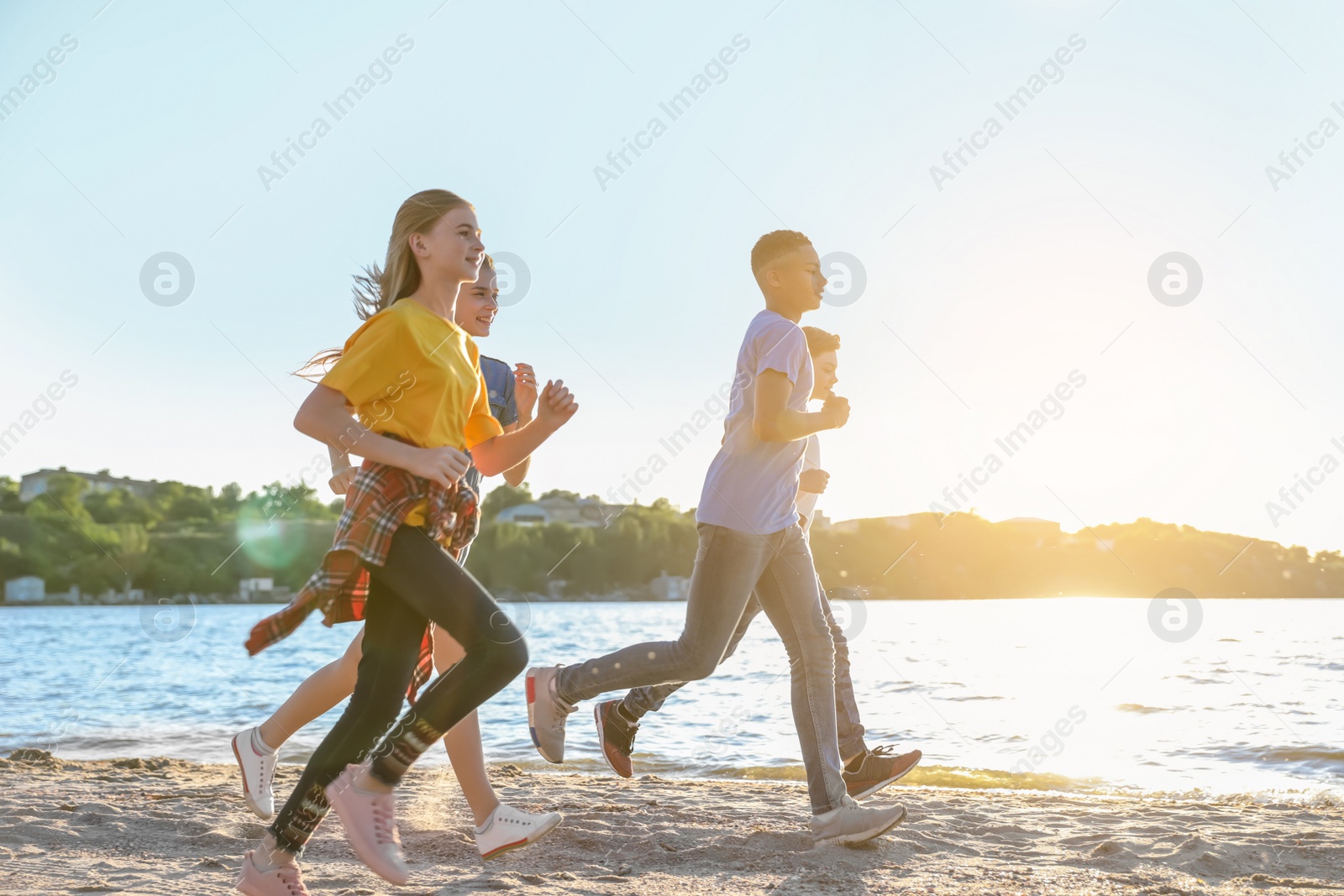 Photo of Group of children running on beach. Summer camp