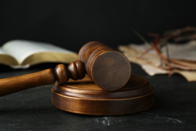 Photo of Wooden judge gavel on black table, closeup