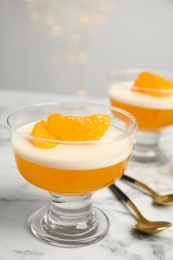 Photo of Delicious tangerine jelly on white marble table