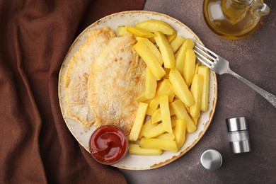 Photo of Delicious fish and chips served on brown table, flat lay