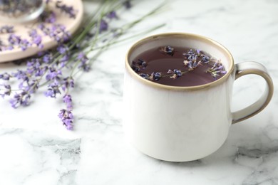 Fresh delicious tea with lavender and beautiful flowers on white marble table