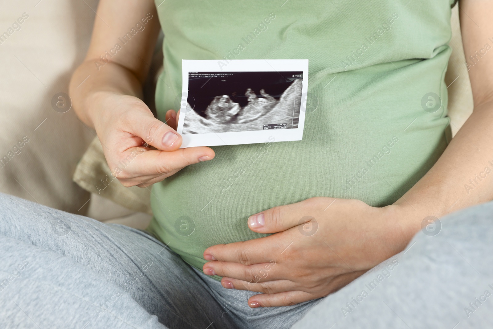 Photo of Pregnant woman with ultrasound picture of baby, closeup