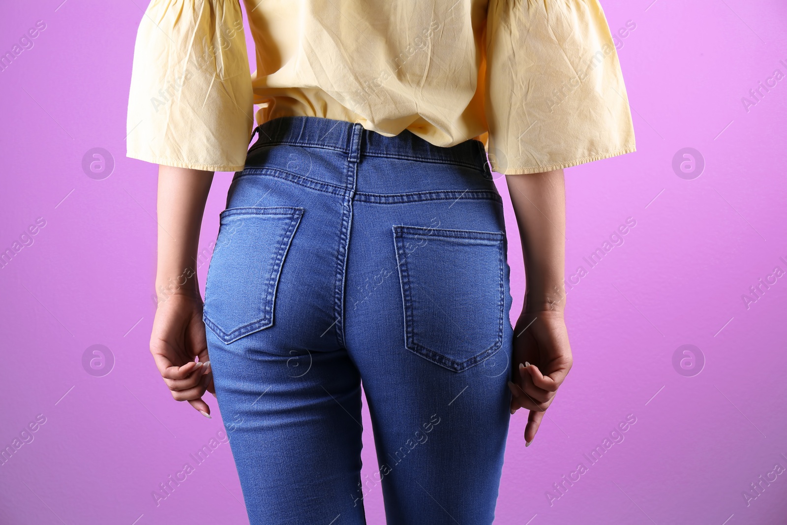 Photo of Woman in stylish blue jeans on color background